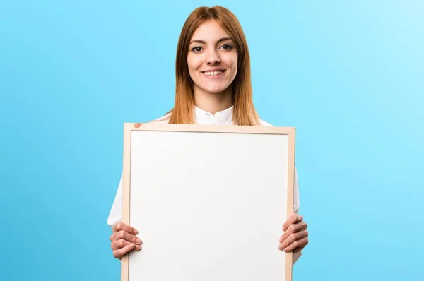 Young doctor woman holding an empty placard on colorful background — Stock Photo, Image