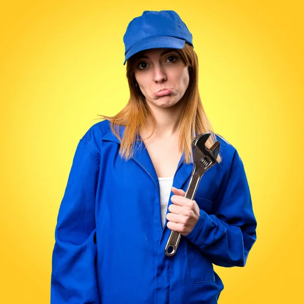 Sad delivery woman on colorful background