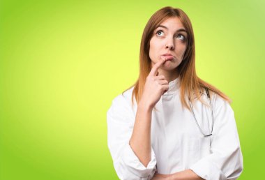 Renkli arka plan üzerinde şüpheleri genç doktor kadın