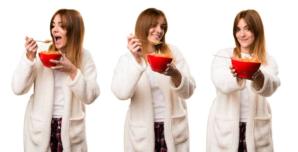 Conjunto de mujer joven en bata comiendo cereales de un tazón — Foto de Stock