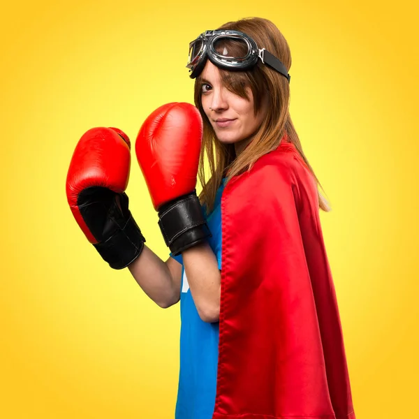 Superhero girl with boxing gloves on colorful background