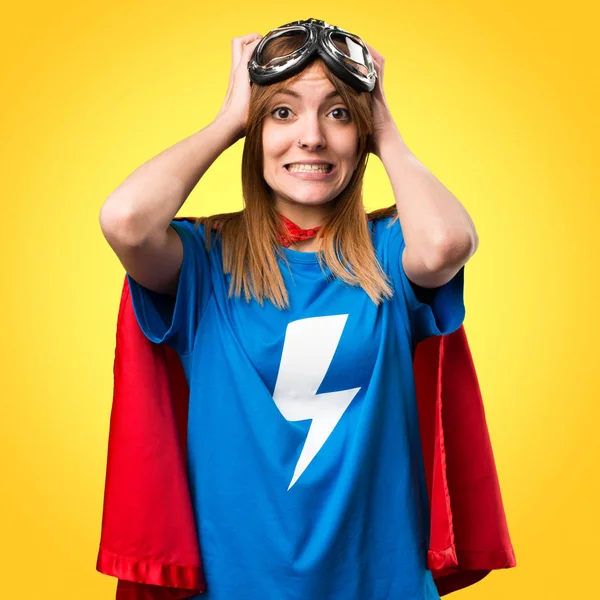 Frustrated pretty superhero girl on colorful background