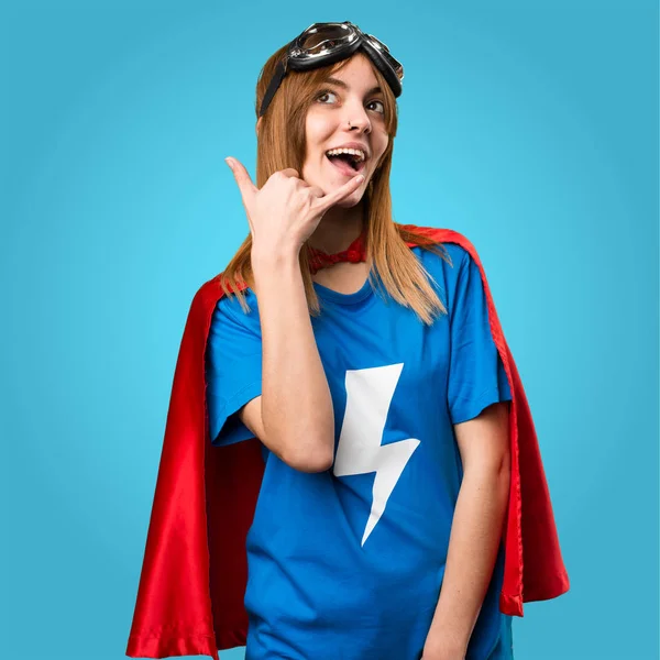 Pretty superhero girl making phone gesture on colorful backgroun