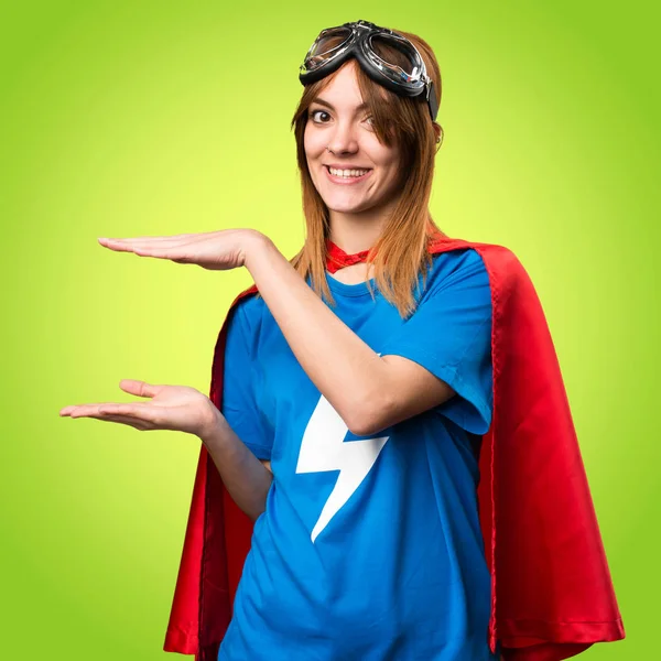 Mooie superheld meisje iets te houden op de kleurrijke achtergrond — Stockfoto