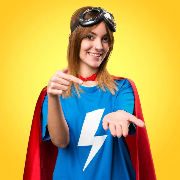 Menina super-herói bonito segurando algo no fundo colorido — Fotografia de Stock