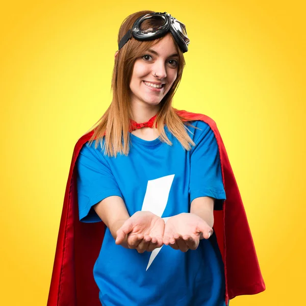 Pretty superhero girl holding something on colorful background
