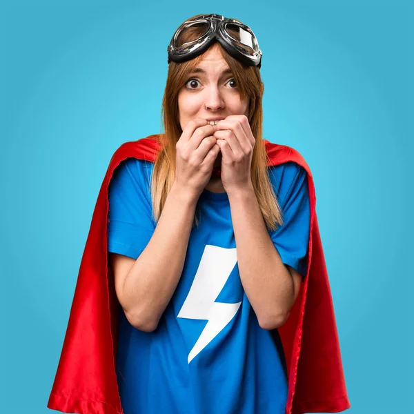 Frightened pretty superhero girl on colorful background