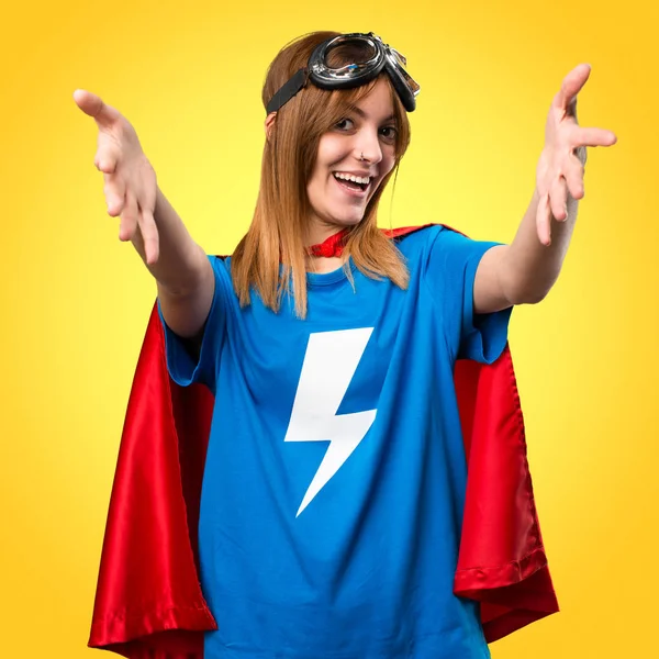 Dívka hezká superhrdina prezentace něco na barevné poza — Stock fotografie