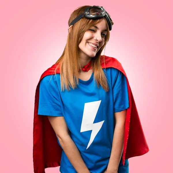 Dívka hezká superhrdina mrkl na barevné pozadí — Stock fotografie