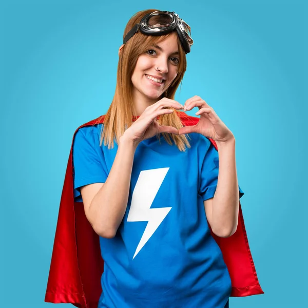 Dívka hezká superhrdina dělat srdce s rukama na barevné — Stock fotografie