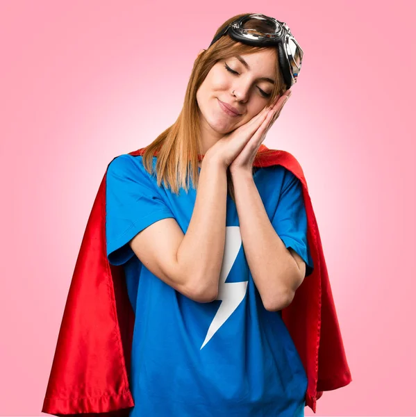 Pretty superhero girl making sleep gesture on colorful backgroun