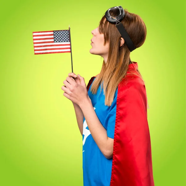 Bastante chica superhéroe sosteniendo una bandera americana en backg colorido —  Fotos de Stock