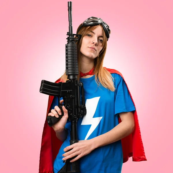 Bella ragazza supereroe in possesso di un fucile su sfondo colorato — Foto Stock