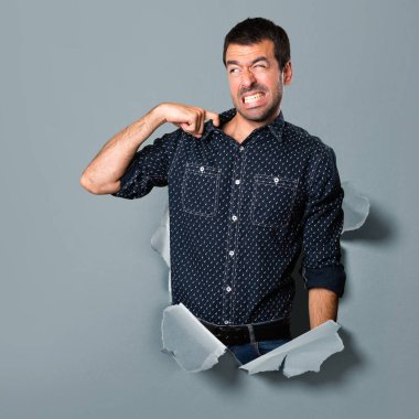 Esmer adam ateşli bir kağıt delikten