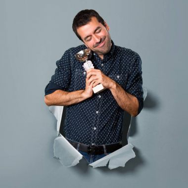 Bir kupa kağıt delik tutan mutlu esmer adam