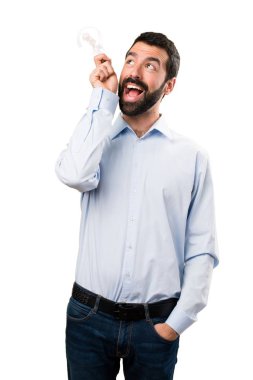 Sakallı bir ampul tutan sürpriz yakışıklı adam