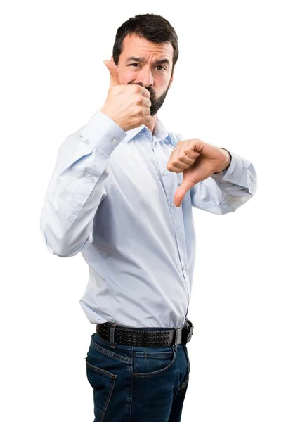 Handsome man with beard making good-bad sign — Stock Photo, Image