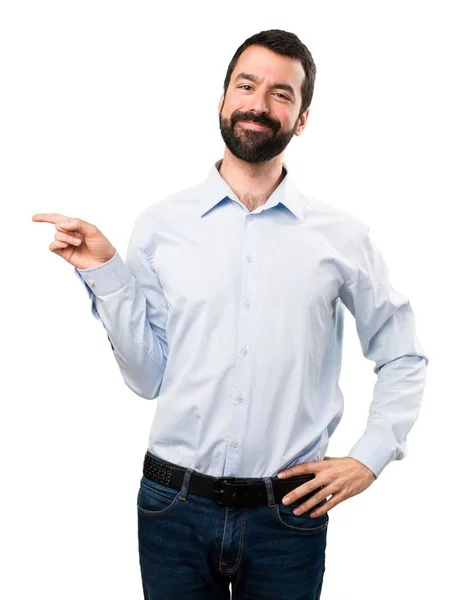 Handsome man with beard pointing to the lateral — Stock Photo, Image