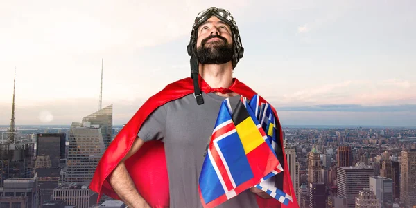 Superheld mit vielen Fahnen, die auf unfokussiertem Stadtradeln nach oben schauen — Stockfoto