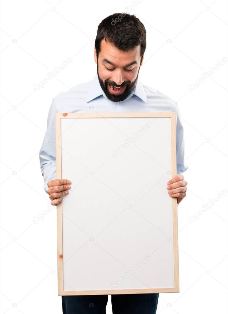 Surprised Handsome man with beard holding an empty placard