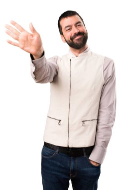 Yelek izole beyaz arka plan üzerinde selamlayan ile yakışıklı adam