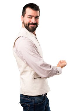 Bir şey izole beyaz arka plan üzerinde sunulması yelek ile yakışıklı adam