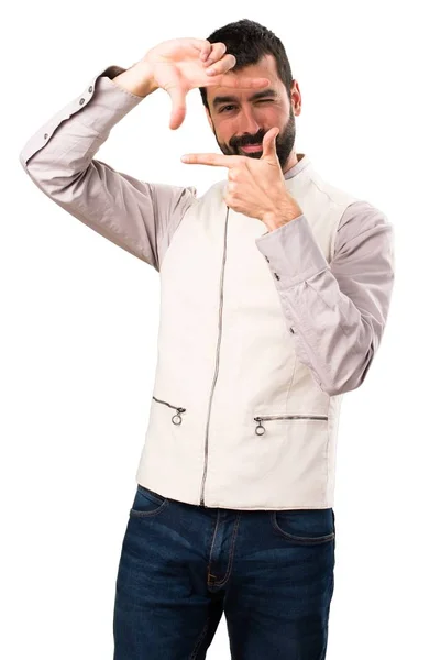 Bonito homem com colete focando com os dedos em fundo branco isolado — Fotografia de Stock