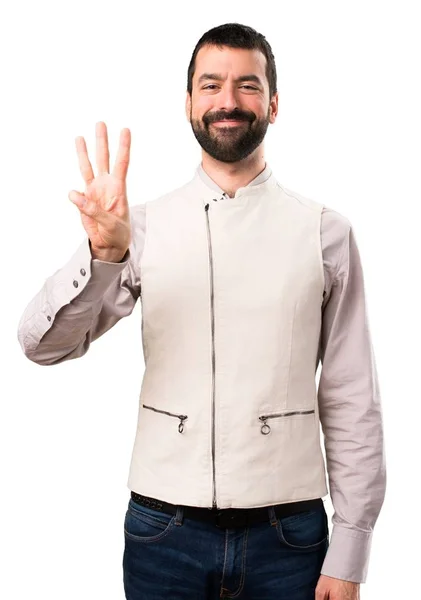 Bello uomo con gilet contando tre su sfondo bianco isolato — Foto Stock