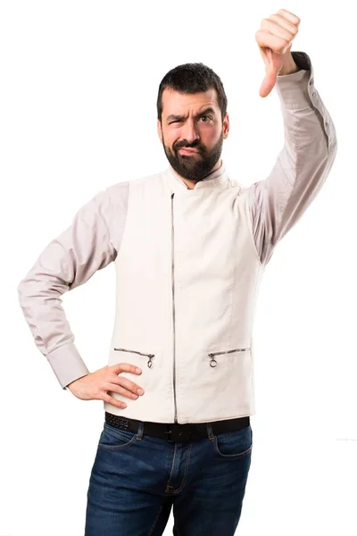 Hombre guapo con chaleco haciendo mala señal sobre fondo blanco aislado — Foto de Stock