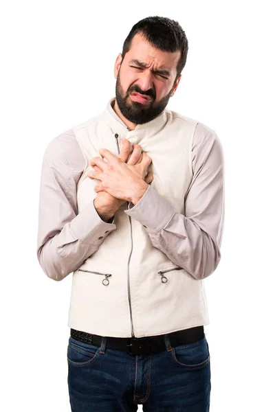 Hombre guapo con chaleco con dolor cardíaco sobre fondo blanco aislado —  Fotos de Stock