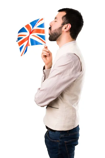 Pohledný muž s vestou drží vlajku Spojeného království na izolované bílém pozadí — Stock fotografie