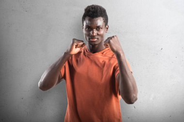 Bir yumrukta yere dokulu arka plan veren güçlü siyah adam