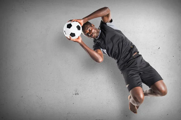 Preto homem jogar futebol no texturizado fundo — Fotografia de Stock