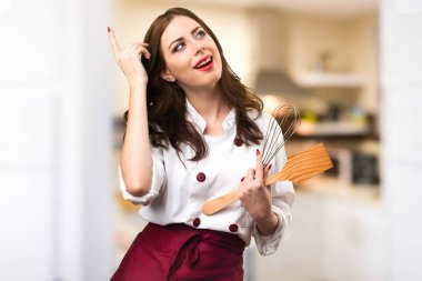 Güzel şef kadın odaklanmamış arka plan üzerinde düşünme