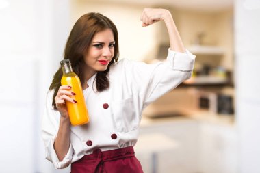 Bir portakal suyu odaklanmamış backgro tutan güzel şef kadın