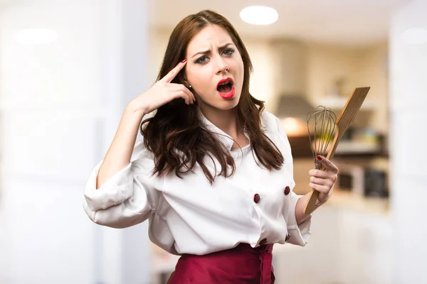 Beautiful chef woman making crazy gesture on unfocused backgroun