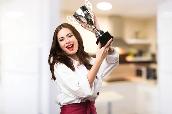 Bella chef donna in possesso di un trofeo su sfondo sfocato — Foto Stock
