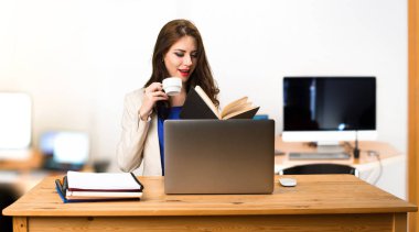 Onu laptop ile çalışan ve bir fincan kahve holding iş kadını