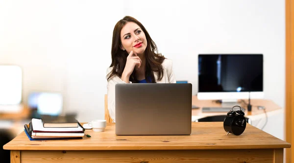 Деловая женщина работает со своим ноутбуком и думает в офисе — стоковое фото