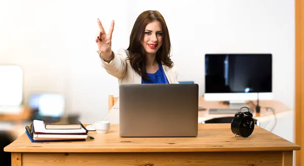 Επιχειρήσεων γυναίκα λειτουργεί με το laptop της και καθιστώντας gestur νίκη — Φωτογραφία Αρχείου