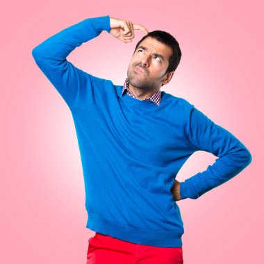 Renkli arka plan üzerinde şüpheleri yakışıklı genç