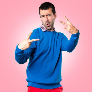 Yakışıklı genç adam yapma zafer jest renkli arka plan üzerinde