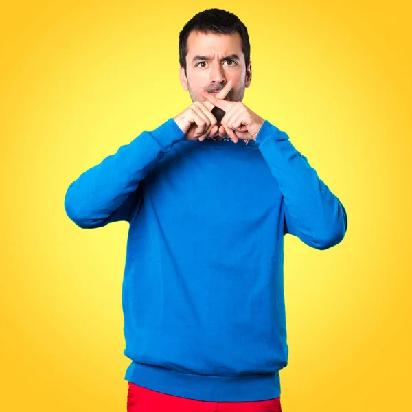 Guapo joven haciendo gesto de silencio sobre fondo colorido — Foto de Stock