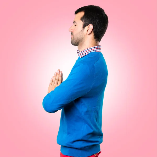 Hombre joven guapo en posición zen sobre fondo colorido — Foto de Stock