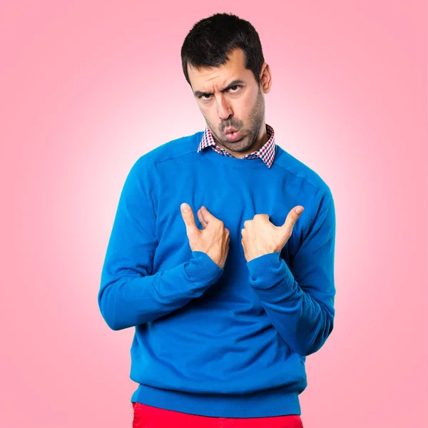 Pohledný mladý muž dělat překvapení gesto na barevné poza — Stock fotografie