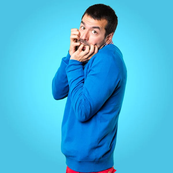 Asustado joven guapo sobre fondo colorido — Foto de Stock