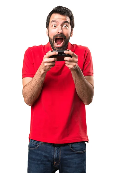 Felice bello giovane uomo che gioca videogiochi oltre isolato bianco — Foto Stock