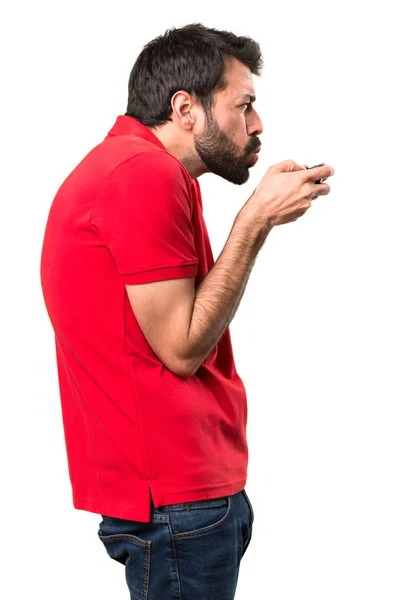 Pohledný mladý muž hraní videoher nad izolované bílé pozadí — Stock fotografie