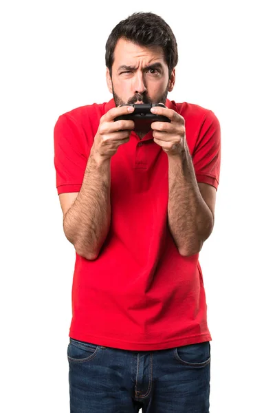 Schöner junger Mann spielt Videospiele über isolierten weißen Backgr — Stockfoto