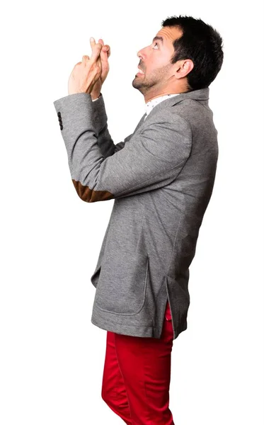 Handsome man with his fingers crossing on isolated background — Stock Photo, Image